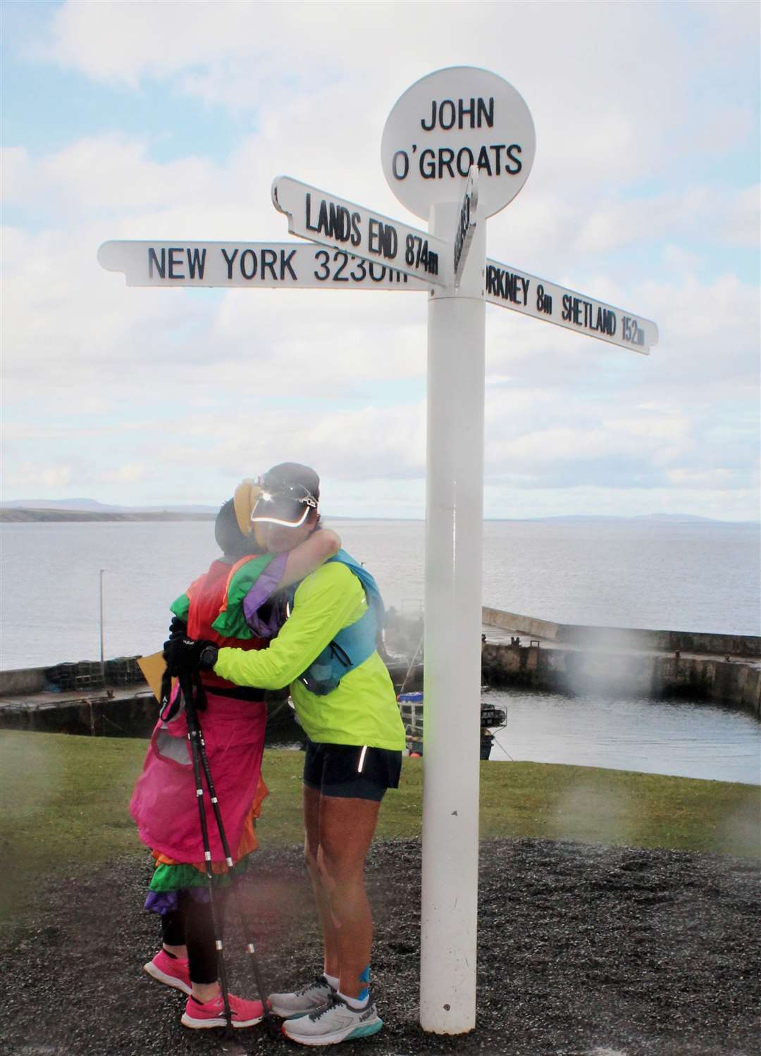 Sara is hugged by Kerry at the John O'Groats signpost after completing her end-to-end challenge. Picture: Eileen Bryant