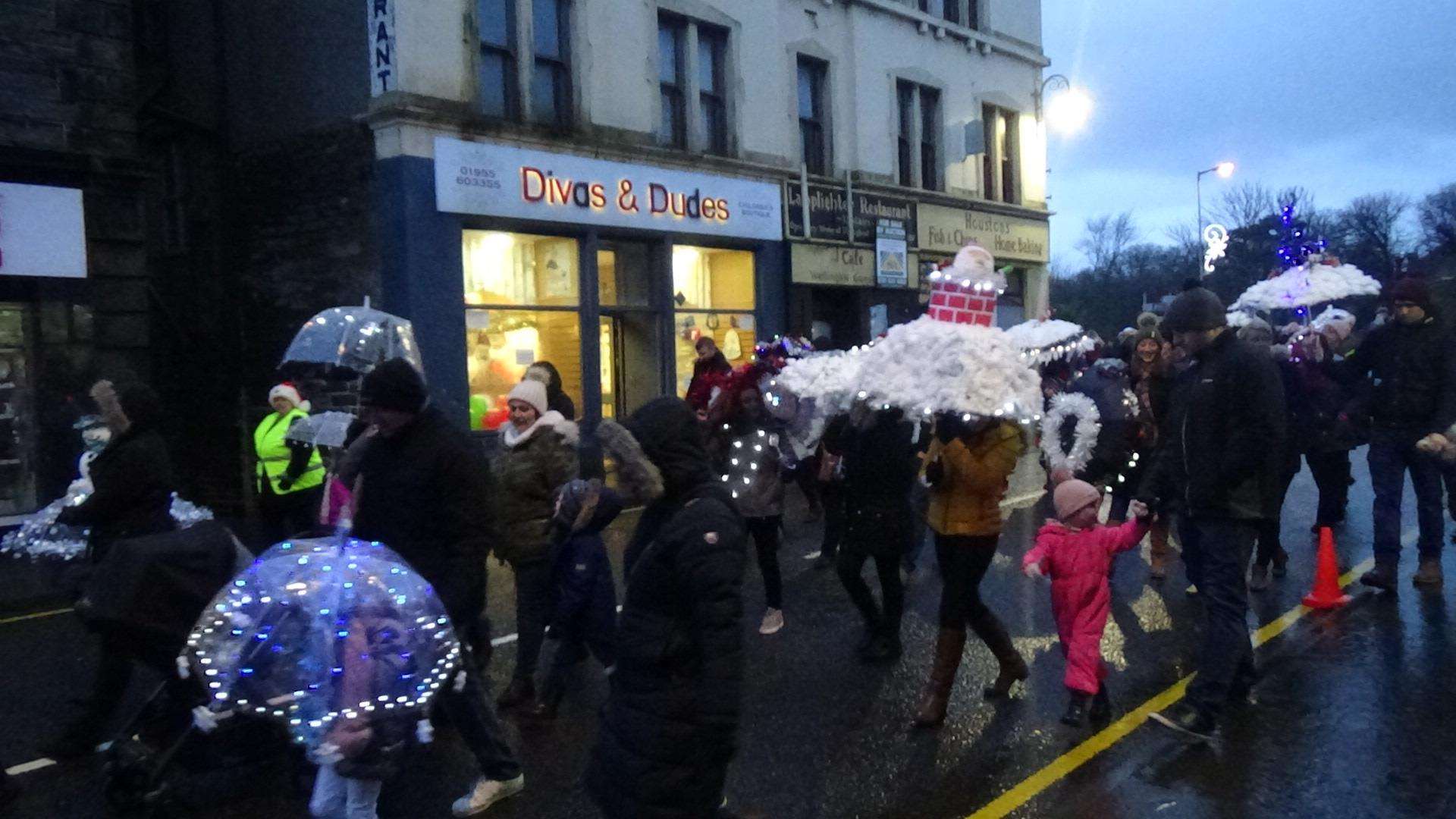 The popular umbrella parade marching to the town centre.