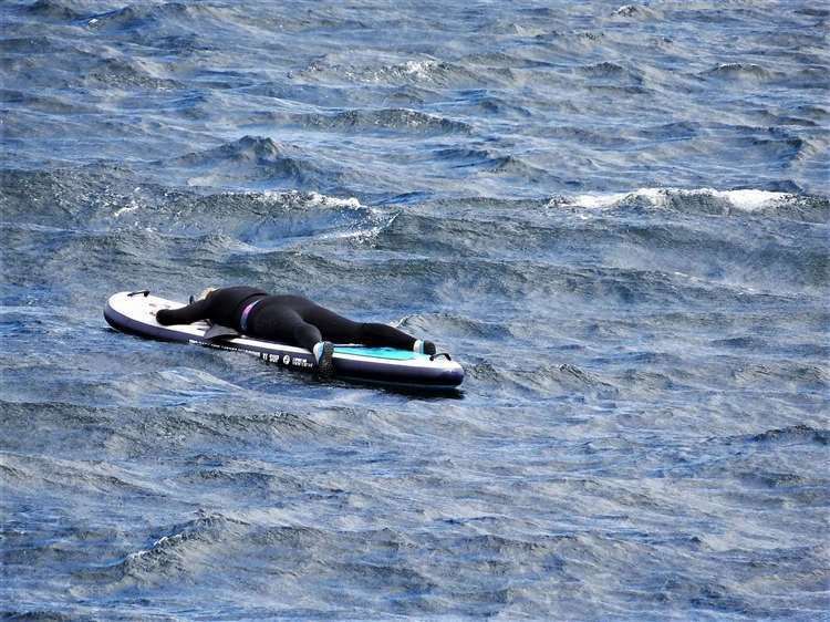 Sheena Thompson is seen clinging on desperately to her paddleboard in Sinclair's Bay. Picture: FV Reaper